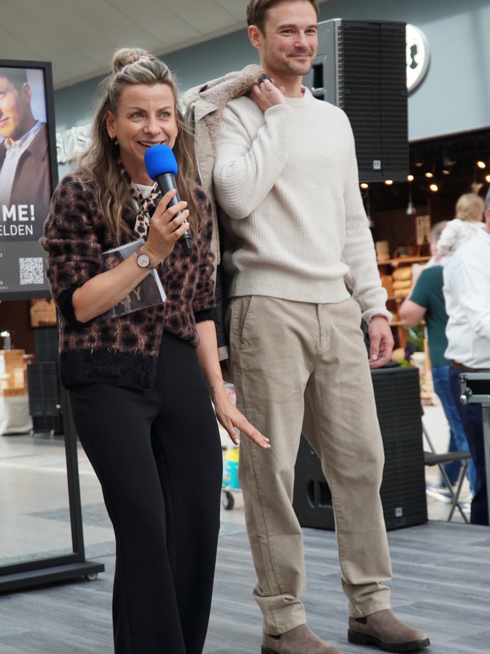 Moderatorin Jenna von Thäne erklärt einen Herrenlook bei der Modenschau von MEIN FISCHER